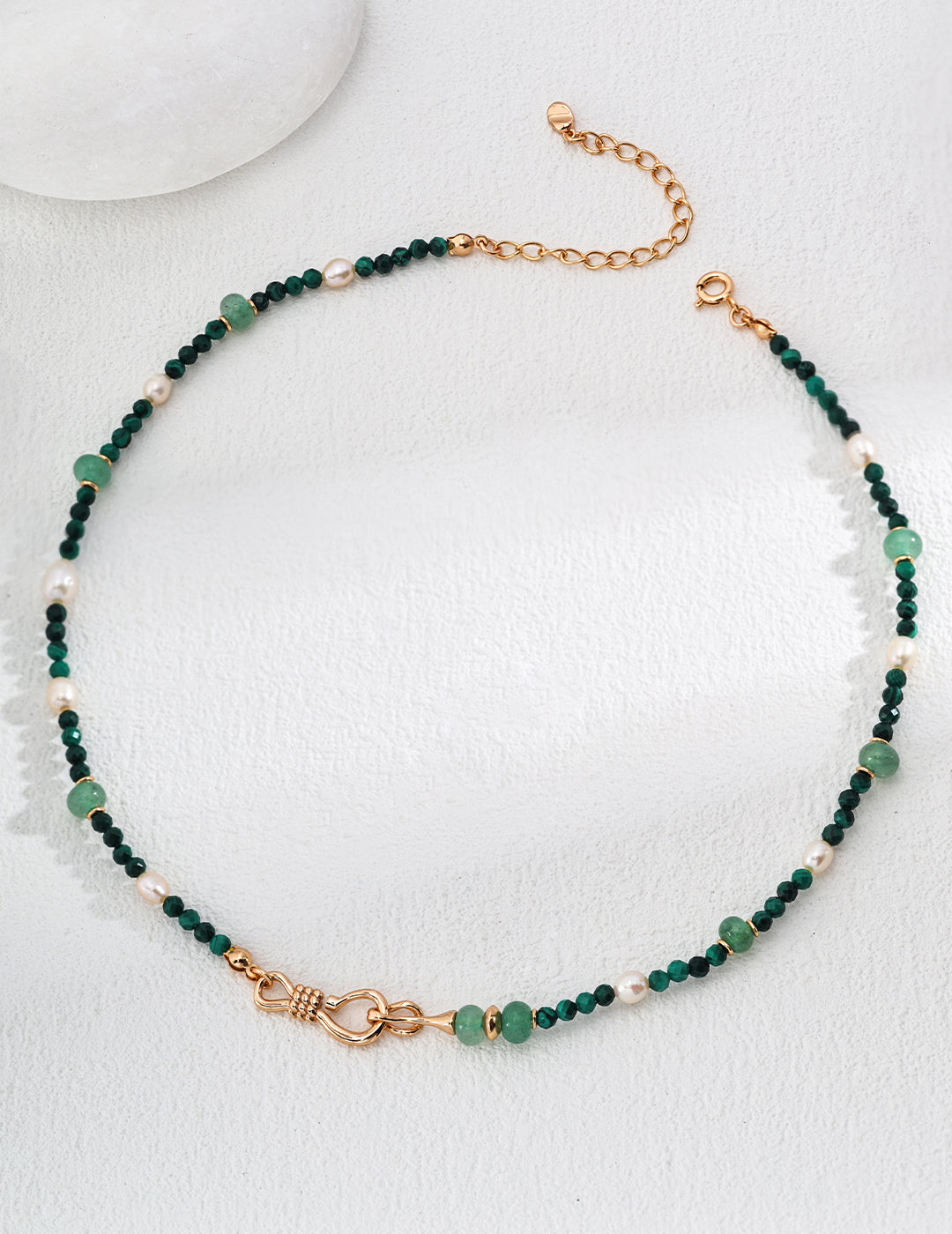 This elegant necklace features a mix of green aventurine beads, pearls, and gold accents, creating a refined and sophisticated design. Its adjustable chain ensures a perfect fit, making it a versatile accessory for any occasion.