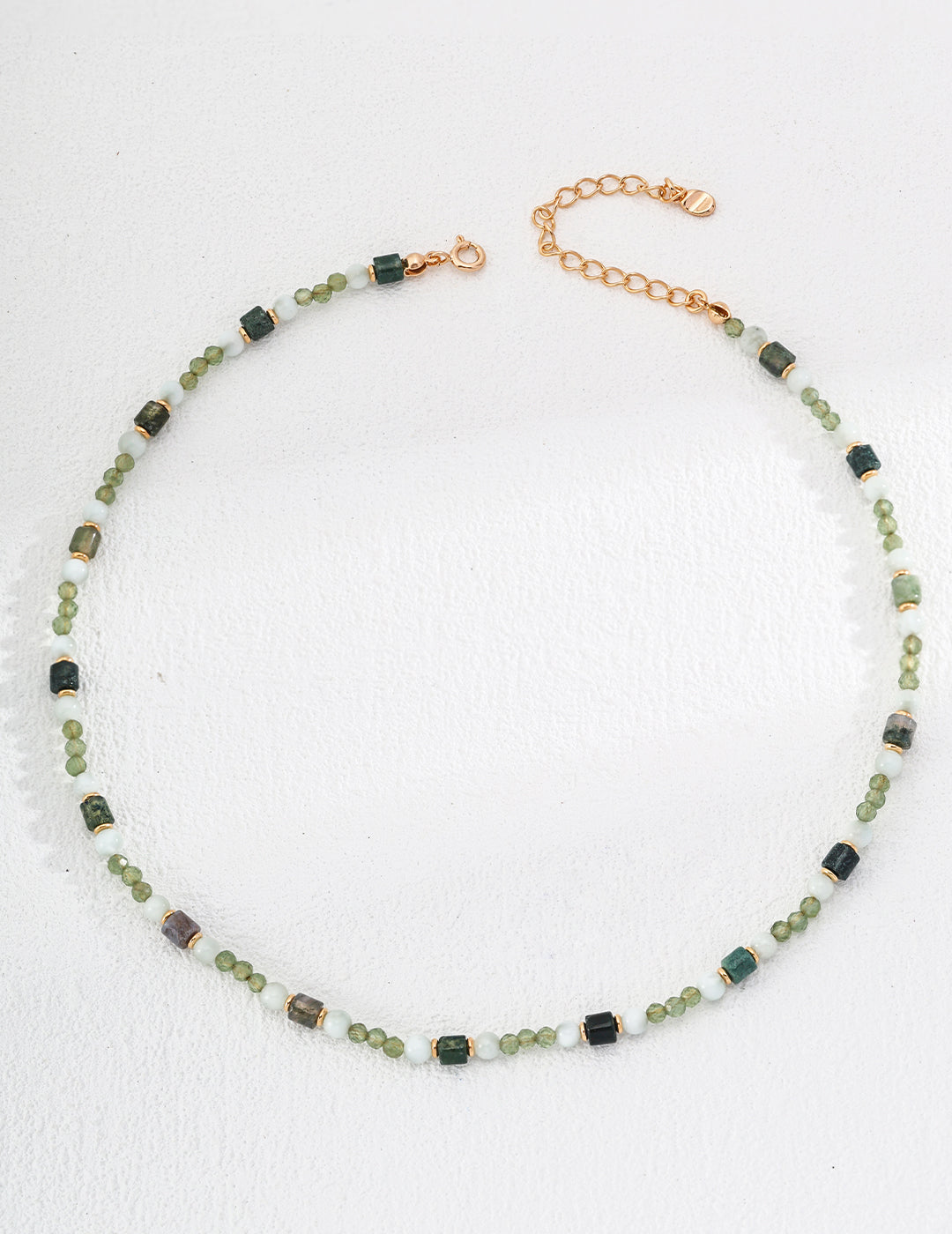 a delicate combination of green gemstones and gold accents, exuding a timeless and minimalist style. Ideal for layering or wearing alone, this handmade piece pairs perfectly with any outfit. Its adjustable chain ensures a comfortable fit, making it a must-have accessory for jewelry lovers seeking everyday sophistication.