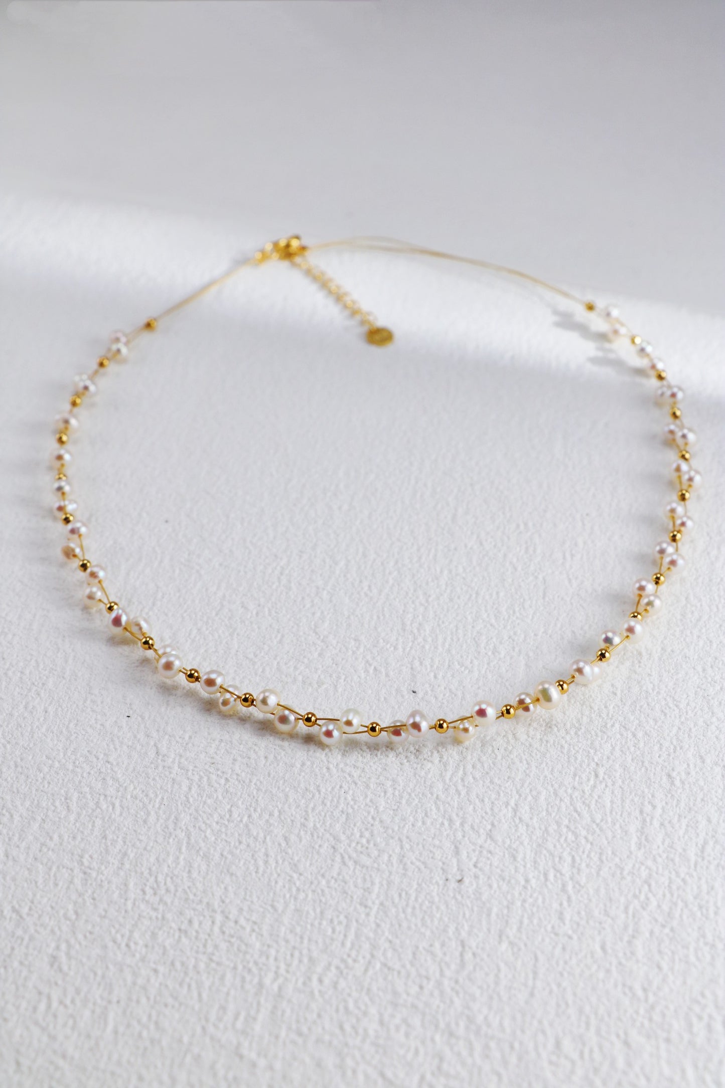 Delicate gold and pearl beaded necklace featuring an adjustable chain for a perfect fit. This minimalist and dainty design is ideal for layering or wearing alone for a subtle, elegant look. Perfect for weddings, bridal jewelry, or everyday fashion. Trendy and lightweight